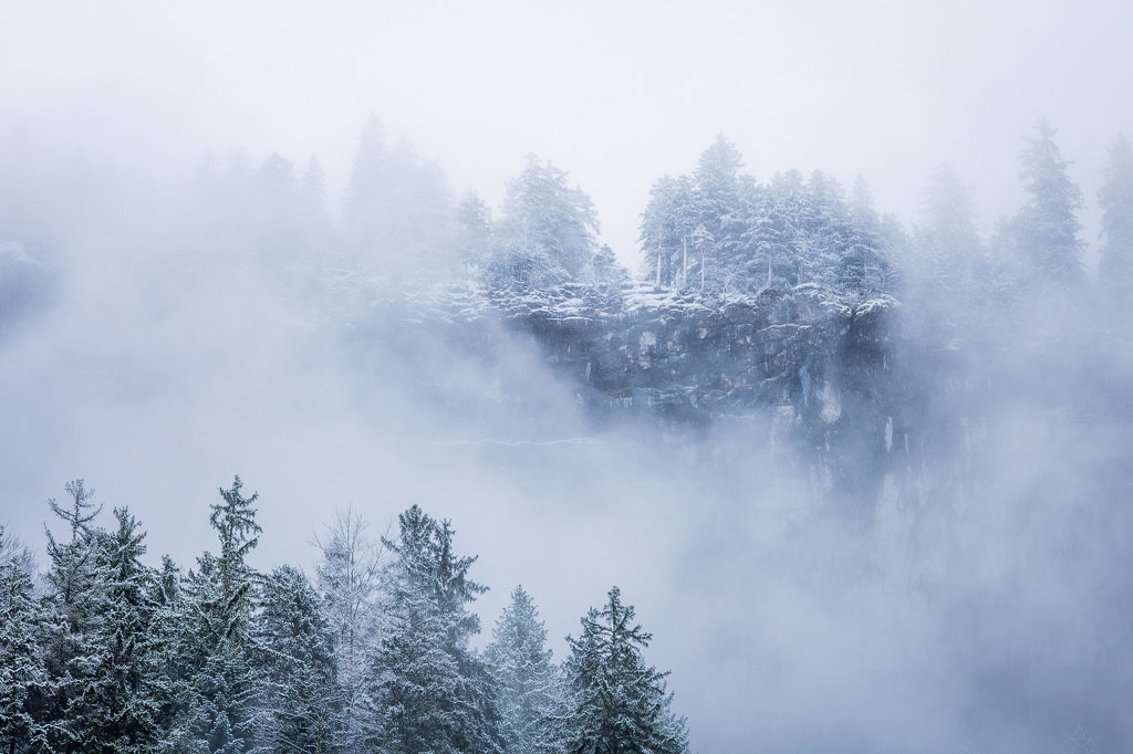 Arbres en haut du falaise apparaissant des une percée de nuages