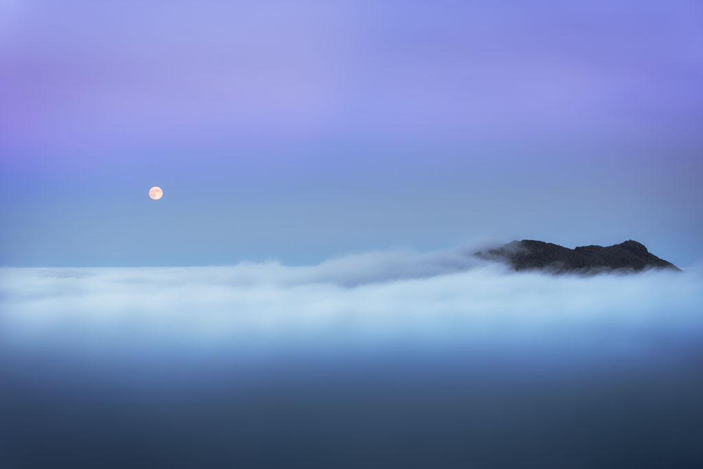Pleine lune au-dessus d'une mer de nuages