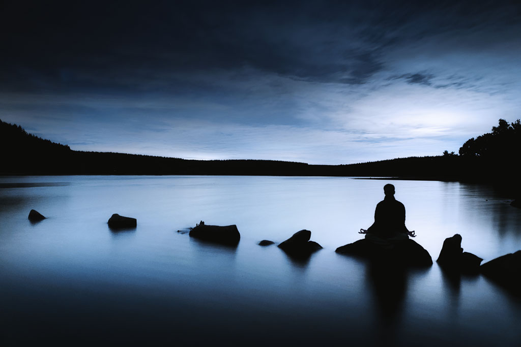 Silhouette en méditation dans une ambiance nocturne