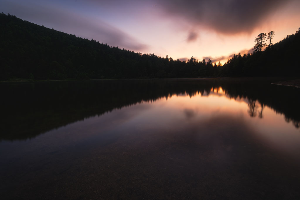 Reflet du coucher de soleil et de la lune sur le lac